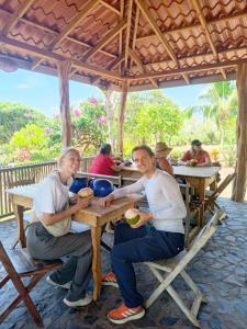 a man and woman sitting at a wooden table at Finca Montaña Sagrada in Mérida