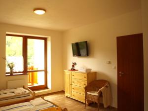 ein Schlafzimmer mit einem Bett, einer Kommode und einem Fenster in der Unterkunft HORSKÁ CHATA SOBÍK in Dolní Morava