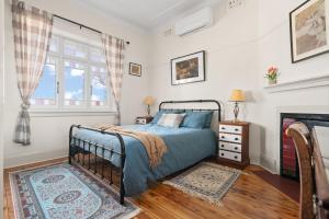 Un dormitorio con una cama y una chimenea. en Sweet Stewart - Walk to CBD Convenient & Cosy, en Bathurst