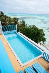 una piscina con 2 sillas y el océano en Endorphins Beach Villa, en Dhiffushi
