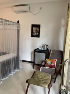 a living room with a chair and a bed at Villa Olga in Unawatuna