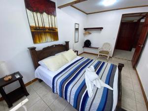 ein Schlafzimmer mit einem Bett mit einer blau-weißen gestreiften Decke in der Unterkunft Apto Cielo Azul in Manuel Antonio