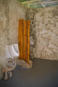 a bathroom with a toilet and a urinal and a sink at Muengtaboon Camping Park in Thung Yai