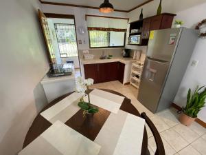 a kitchen with a table and a stainless steel refrigerator at Apto Cielo Azul in Manuel Antonio +13 photos
