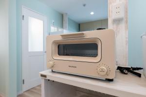 a beige toaster oven sitting on top of a counter at 長期割がお得 最大8名 2BR 55平米 東京駅電車10分 TDR スカイツリー好アクセス 駐車場予約 送迎有 HOTEL DREAM MUSIC Tōyōchō pastel in Tokyo