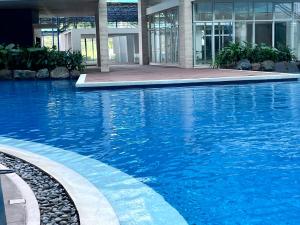 a large blue swimming pool in a building at Cozy Nook in the City in Manila