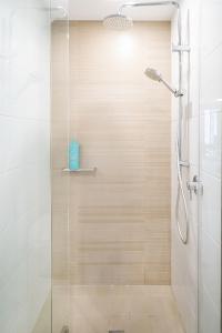 a shower with a glass door in a bathroom at Little Bay Haven-Stylish Coastal Apartment in Sydney +26 photos