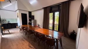 a dining room with a large wooden table and chairs at MAI Villa Da Nang in Da Nang