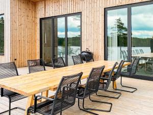 a wooden table and chairs on a deck at 4 star holiday home in Håcksvik in Håcksvik