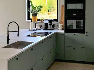 a kitchen with a sink and a stove top oven at 4 star holiday home in Håcksvik in Håcksvik +35 photos