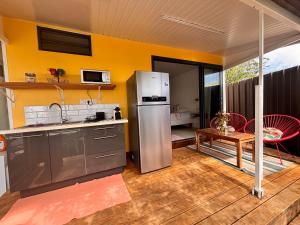 a kitchen with a stainless steel refrigerator and a table at Airport Pamatai Studio in Faaa +7 photos