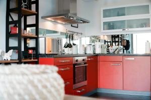 a kitchen with red cabinets and a red oven at Glisch a vita in Mathon