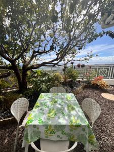 a table and chairs with a green and white table cloth at Airport Pamatai Studio in Faaa