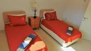 1 dormitorio con 2 camas con sábanas rojas y mesita de noche en Villa Christina, en Pafos 22 fotos más