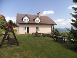 a house with picnic tables in the yard at Ostoja in Polańczyk