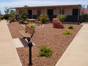 un banco de parque con un edificio al fondo en Karratha Lodge TWA en Karratha