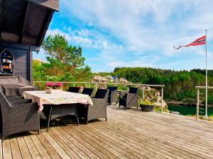 a patio with a table and chairs on a deck at 6 person holiday home in Urangsvåg in Steinsbø +77 photos