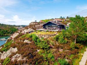 a house on top of a hill with a river at 6 person holiday home in Urangsvåg in Steinsbø