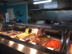 Karratha Lodge TWA في كاراثا: شيف يحضر الطعام في مطبخ المطعم