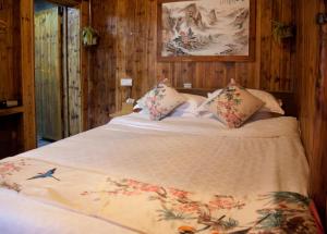 a large bed in a room with wooden walls at Old Street Xi'an Inn (Free Pick up Service) in Huangshan