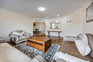 a living room with a couch and a table at Spacious Holiday Home in a Superb Location in Auckland
