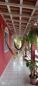a hammock hanging from a porch of a house at Pousada Ray Sol - Centro Arraial d Ajuda in Arraial d'Ajuda