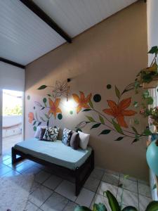 a bedroom with a bed with a flower mural on the wall at Pousada Ray Sol - Centro Arraial d Ajuda in Arraial d'Ajuda +105 photos