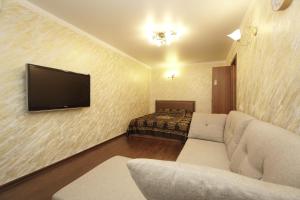 a living room with a couch and a flat screen tv at Lenina 1G Apartment in Zheleznovodsk