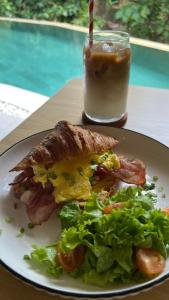 un plato con un sándwich y una ensalada y una bebida en Greenforest Anahata 5 Star Villa Hotel, en Canggu 65 fotos más