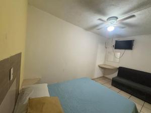 ein kleines Zimmer mit einem Bett und einer Couch in der Unterkunft Hospedaje Ferchitos in Sofía