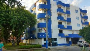 a building with blue balconies on the side of it at Aparta Hotel Jardines del Caney in Cali