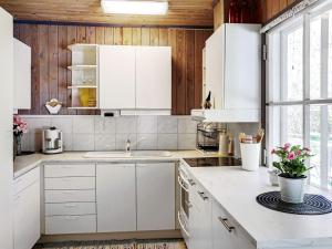 a kitchen with white cabinets and a sink at 4 person holiday home in Hemse in Hemse