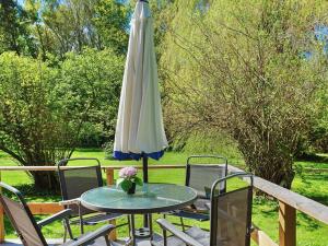 an umbrella and a table and chairs on a patio at 4 person holiday home in HEMSE in Hemse