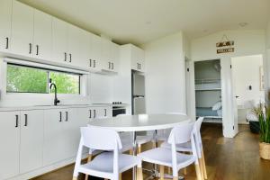 a kitchen with white cabinets and a white table and chairs at BIG4 Wilsons Prom Holiday Park in Yanakie +16 photos