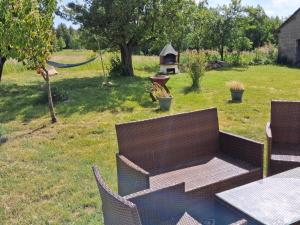 a backyard with a table and chairs and a bird feeder at Leśny zakątek in Rękusy