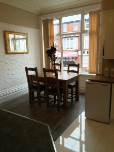 a dining room with a table and chairs and a window at Somerset House Apartments in Blackpool