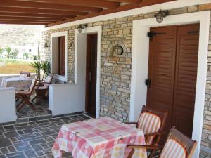 a patio with a table and chairs on a house at Pension Irini-Vicky in Ios Chora