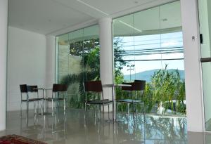 a room with glass chairs and a table with a view at Suítes Trindade in Florianópolis +21 photos
