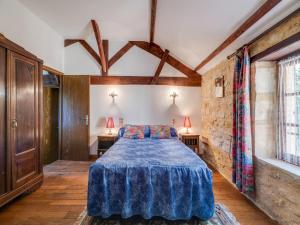 a bedroom with a bed with a blue blanket at Cosy holiday home with garden in Villefranche-du-Périgord