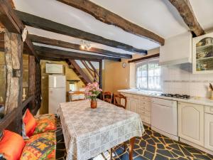 a kitchen with a table with a vase of flowers on it at Cosy holiday home with garden in Villefranche-du-Périgord