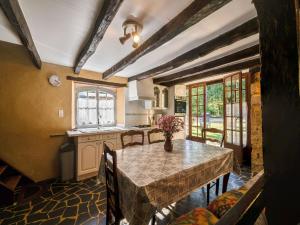 a kitchen with a table with a vase of flowers on it at Cosy holiday home with garden in Villefranche-du-Périgord