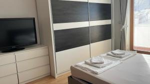 a bedroom with a tv and a bed with a dresser at BT Lux apartment 2 in Skopje +93 photos