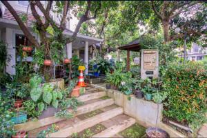 a house with a garden with plants and a set of stairs at Homestay Helinium RedPartner in Bogor