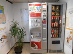 a coca cola vending machine with a drink inside at Premiere Classe Brest Gouesnou Aeroport in Gouesnou