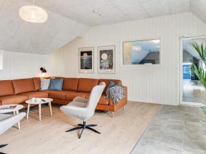 a living room with a couch and a chair at 5 star holiday home in Ringkøbing in Ringkøbing