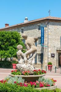 a statue in front of a building with flowers at Frédéric Carrion - Cuisine, Hôtel & Spa in Viré