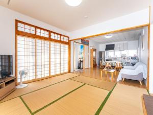Tsuhaにあるニライハウス大宜味のソファとテレビのあるリビングルーム