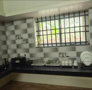 SomvārpetにあるNature Chirps Coorg farmview villaのキッチン(食器カウンター、窓付) +8枚の写真