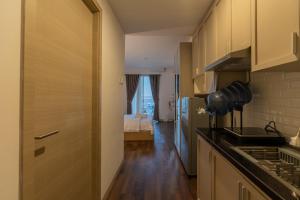 a kitchen with a counter top and a room with a bed at Mataram City Apartment Urban View in Kejayan
