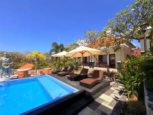 a swimming pool with chairs and umbrellas next to a house at Pooja Ocean View Cottage in Nusa Penida +33 photos
